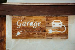 Un cartello che dice garage con una macchina e una freccia di Hotel Alpenrose ad Arabba
