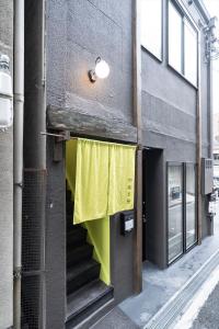 a building with a yellow curtain on the side of it at かゑる屋 in Kobe
