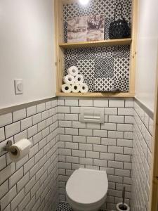 ein Bad mit einem WC und einer weiß gefliesten Wand in der Unterkunft Appartement cosy au sein d’un hameau verdoyant 