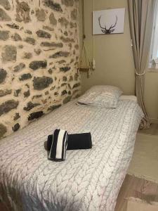 ein schwarzer und weißer Hut auf einem Bett in der Unterkunft Appartement cosy au sein d’un hameau verdoyant 