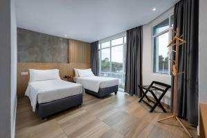 a hotel room with two beds and a window at The Bayou Hotel Langkawi in Pantai Cenang
