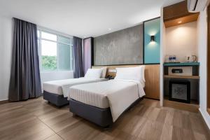 a hotel room with two beds and a fireplace at The Bayou Hotel Langkawi in Pantai Cenang