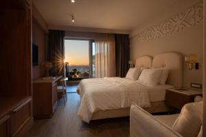 a hotel room with a bed and a desk and a window at Oniro Boutique Hotel in Toroni