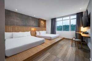 a hotel room with two beds and a desk at The Bayou Hotel Langkawi in Pantai Cenang