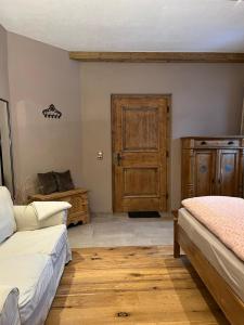 a bedroom with two beds and a wooden door at Zimmer in Kirchberg in Tirol in Kirchberg in Tirol