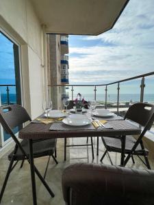 einen Tisch mit Gläsern und Tellern auf dem Balkon in der Unterkunft Almasarat Tower Sea View in Dschidda