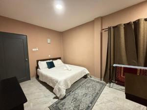 a small bedroom with a bed and a curtain at VILLA SERI MUTIARA in Kuah