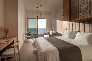 a bedroom with a bed and a desk and a window at Oniro Boutique Hotel in Toroni