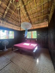 a room with a bed in a straw hut at Phayam Valley Homestay in Ko Phayam