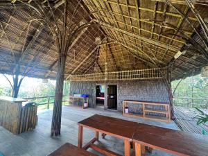 une chambre avec une table et un toit de paille dans l'établissement Phayam Valley Homestay, à Ko Phayam