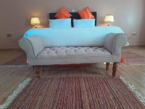 uma cama com um sofá azul num quarto em PENETY AMBOSELI RESORT em Amboseli