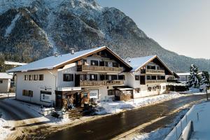 a ski lodge with a mountain in the background at Fewo Am Mühlbach 5 AMB5 in Mittenwald