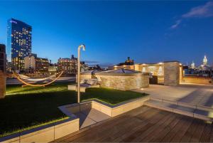 a rooftop patio with a view of a city at night at Rasila SoHo in New York