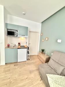 ein Wohnzimmer mit einem Sofa und einer Küche in der Unterkunft Studio center 104 in Cannes