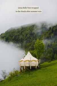 a tent sitting on a hill next to a lake at Glamping Tago in Khulo