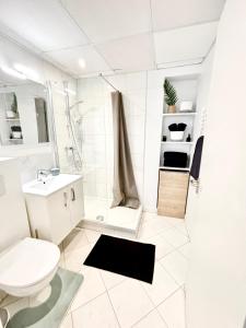 a white bathroom with a toilet and a sink at Studio center 104 in Cannes