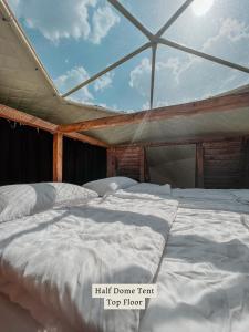 a large white bed in a room with a roof at Glamping Tago in Khulo
