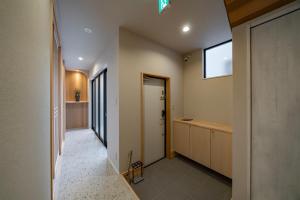 un pasillo de una casa con puerta y ventana en Besso姫路 en Himeji