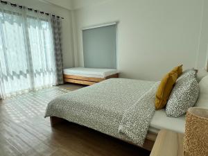 a bedroom with a large bed and a window at Ida Japanese pool villa in Chalong 