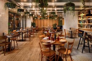 - un restaurant avec des tables et des chaises dans une salle dans l'établissement Palmiers by Fassbind, à Lausanne