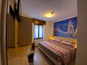 1 dormitorio con 1 cama y una pintura en la pared en Hotel Sciatori en Temù