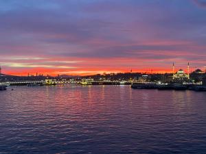 una puesta de sol sobre un cuerpo de agua con una ciudad en Ferah Otel, en Estambul