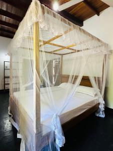 een slaapkamer met een bed bedekt met klamboes bij Villa Gihan in Hikkaduwa