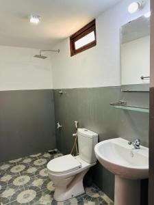 een badkamer met een wit toilet en een wastafel bij Villa Gihan in Hikkaduwa
