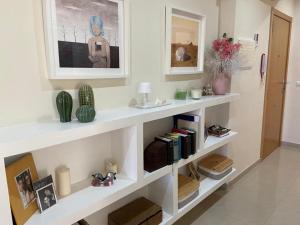 una sala de estar con estanterías blancas con libros en ÁTICO HOME y garaje, Algemesi Home, en Algemesí