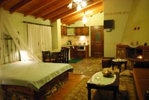 a living room with a bed and a kitchen at Tzivaeri in Likodhrómion