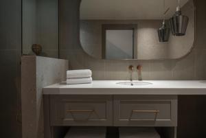 a bathroom with a sink and a mirror at Oniro Boutique Hotel in Toroni