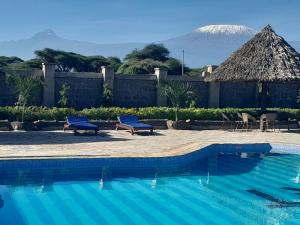 a swimming pool with a mountain in the background at PENETY AMBOSELI RESORT in Amboseli