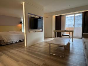 Habitación de hotel con sofá, mesa y cama en 台北馥華商旅 松江館 en Taipéi