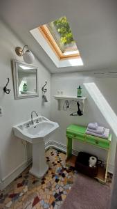 ein Badezimmer mit einem Waschbecken und einem Dachfenster in der Unterkunft Le Manivert in Vitry-Laché