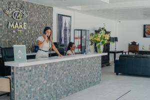 une femme qui parle sur un téléphone portable à un comptoir dans l'établissement Mare Hotel, à Dos Hermanas