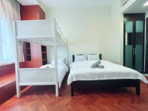 Tanjong TokongにあるStrait Quay Marina Cozy Suite with Bathtub by Uptrend Home Managementのベッドルーム1室(白いベッド1台、白い二段ベッド1組付)