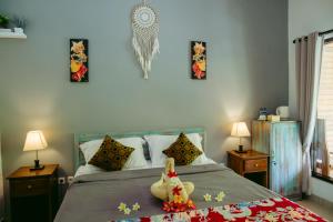 un dormitorio con una cama con un animal de peluche en Kinton Guesthouse, en Nusa Penida