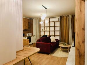 ein Wohnzimmer mit einem roten Sofa und einem Tisch in der Unterkunft Joy City Stay Vivalia 7B-13 in Timişoara