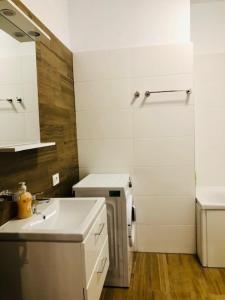 ein weißes Badezimmer mit einem Waschbecken und einem Spiegel in der Unterkunft Joy City Stay Vivalia 7B-13 in Timişoara