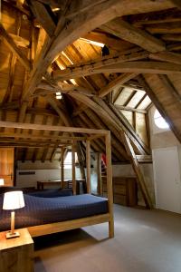 Habitación con cama en una habitación con techos de madera. en Château de Perreux, The Originals Collection en Amboise