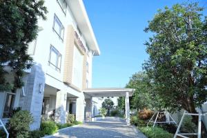 un edificio blanco con una pasarela delante de él en THE NAVY HOUSE HOTEL, en Sattahip