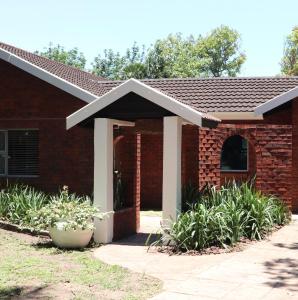 a red brick house with an arched doorway at Pompano Corner in Richards Bay