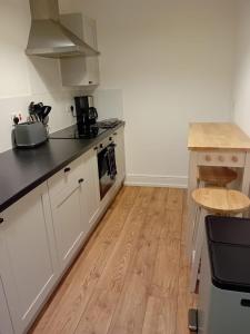 a kitchen with white cabinets and a wooden floor at Colville House in Lincolnshire