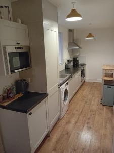 a kitchen with white cabinets and a washer at Colville House in Lincolnshire