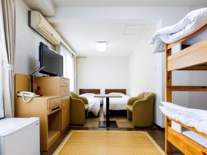 a dorm room with a bunk bed and a desk with a tv at Seoul Garden Hotel in Hakodate