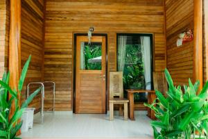 una entrada a una casa de madera con puerta de madera en Kinton Guesthouse, en Nusa Penida