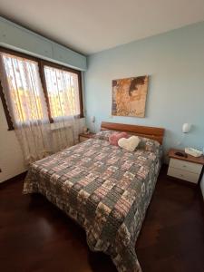 a bedroom with a bed with a blanket and two windows at Ostia Sunsets • Home near Rome and Airport in Lido di Ostia