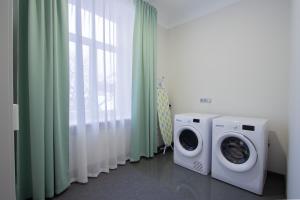 a laundry room with two washing machines and a window at Laima V. Apartments in Riga