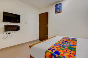 a bedroom with a bed and a flat screen tv at FabExpress Rithun Residency in Bangalore