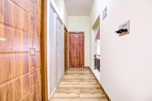 a hallway with a wooden door and a wooden floor at FabExpress Rithun Residency in Bangalore